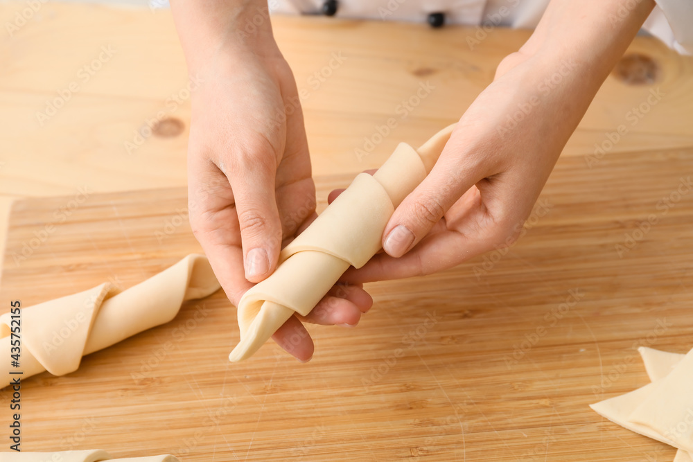 Woman cooking croissants in kitchen, closeup