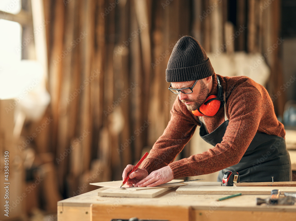 Joiner making marks on wooden detail