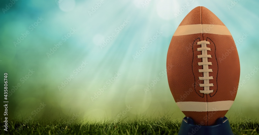 Composition of rugby ball on pitch with copy space with spots of light on blue background