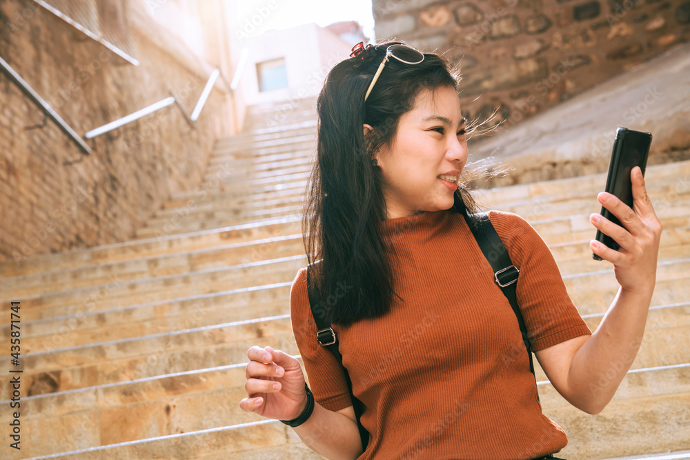 魅力亚洲女性旅行者旅游手用智能手机生活视频通话观光老石头