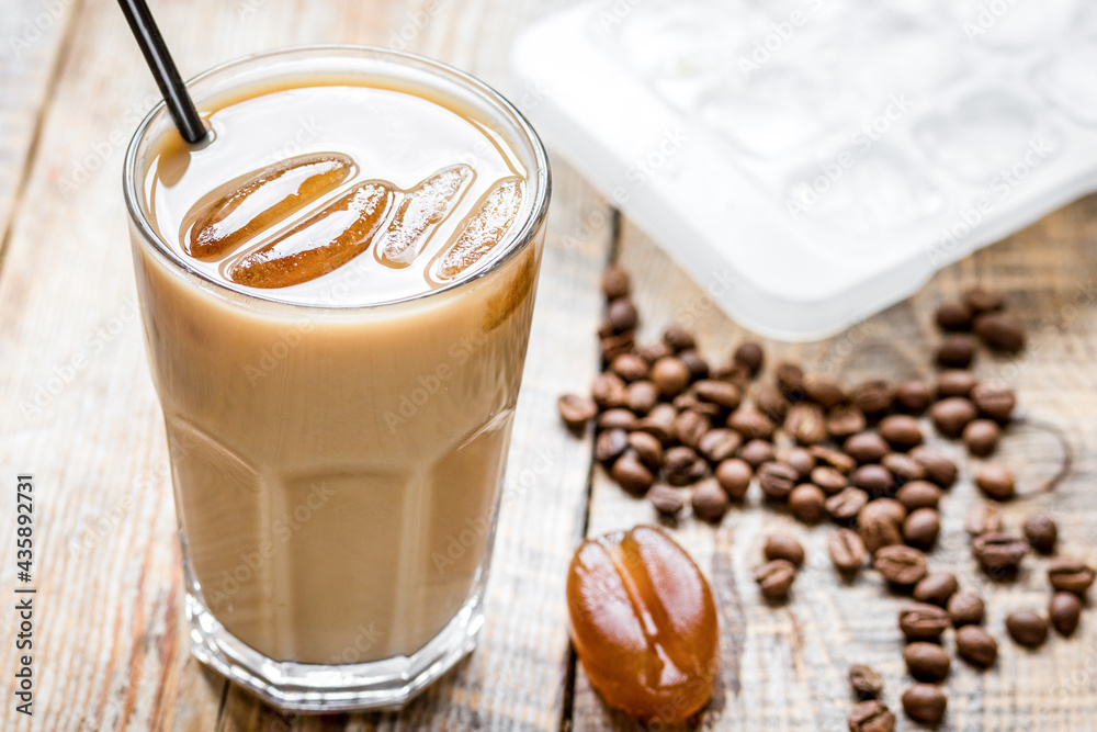 iced coffee with beans for cold summer drink on wooden background