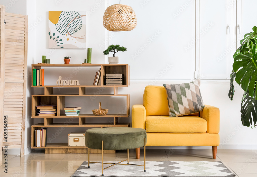 Interior of modern room with shelf unit and armchair