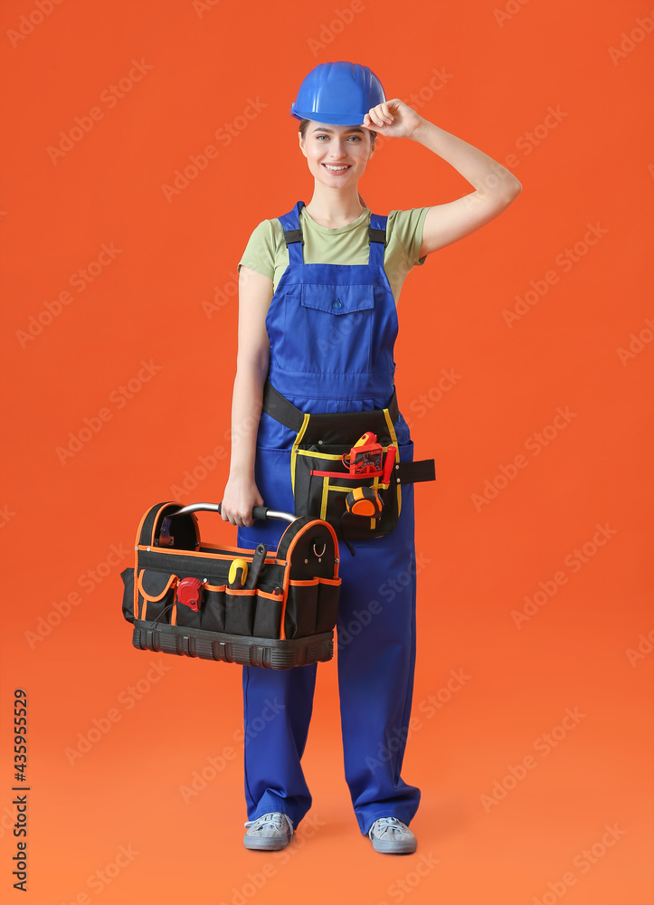 Beautiful female electrician with tools on color background