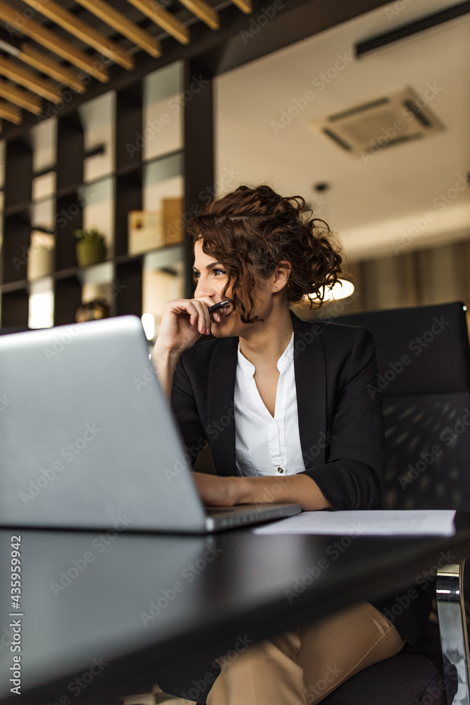 Portrait of a happy businesswoman at office desk.