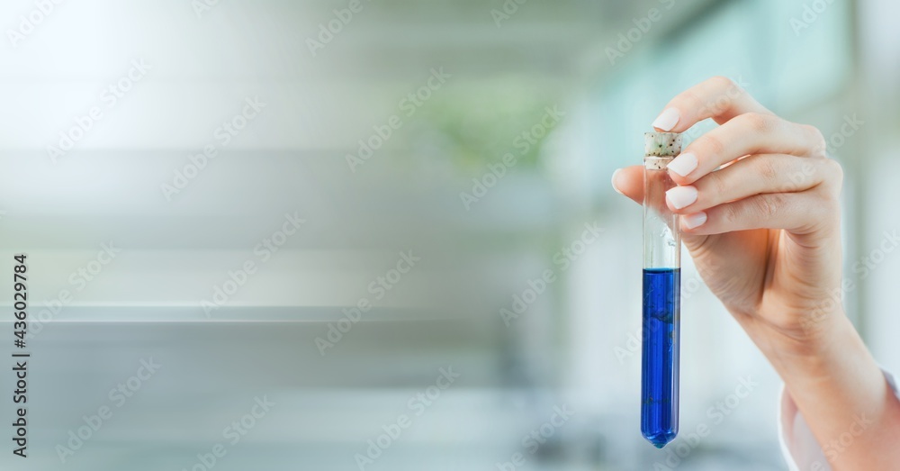 Composition of hand of lab technician holding test tube of blue liquid, with blurred copy space