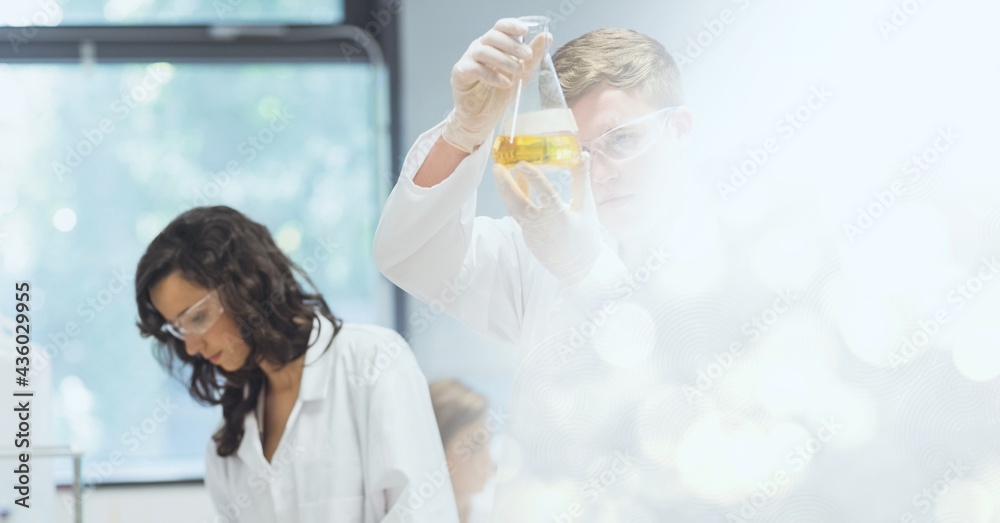 Composition of two female lab technicians at work, with white bokeh copy space to right