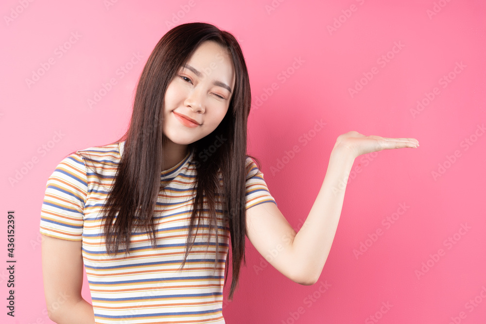 Young Asian woman posing on pink background