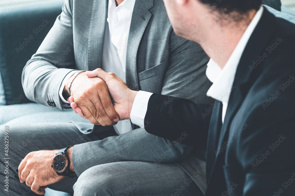 Businessman handshake with another businessman partner in modern workplace office. People corporate 