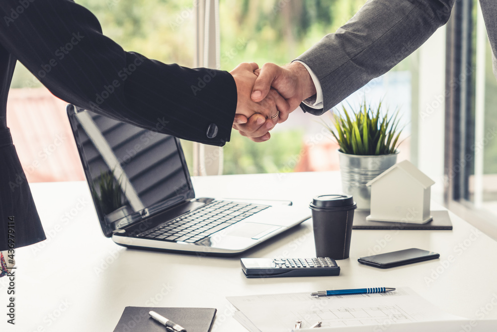 Businessman executive handshake with businesswoman worker in modern workplace office. People corpora