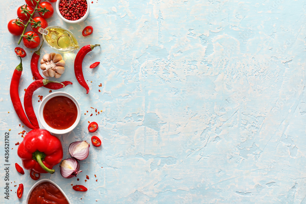 Composition with tasty chili sauce and ingredients on color background