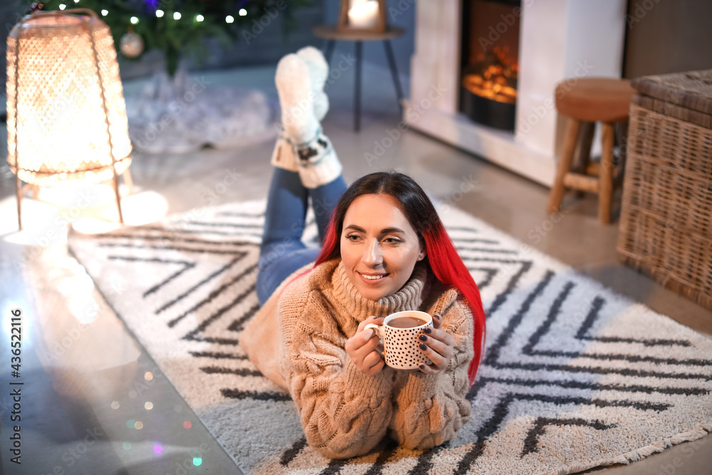 Beautiful woman with cup of cocoa at home on Christmas eve