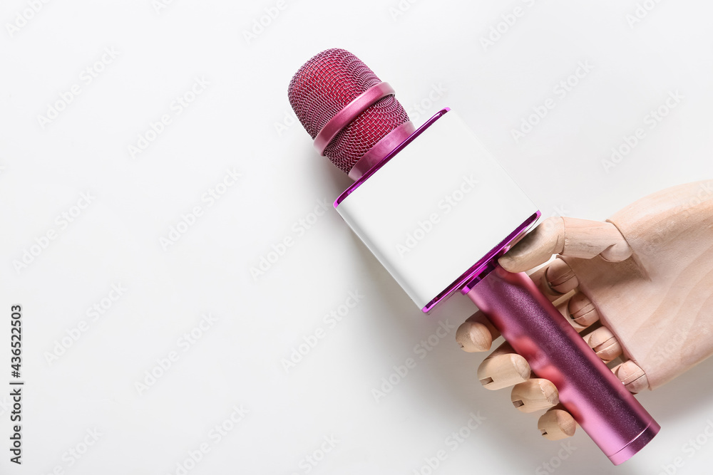 Wooden hand with modern microphone on white background