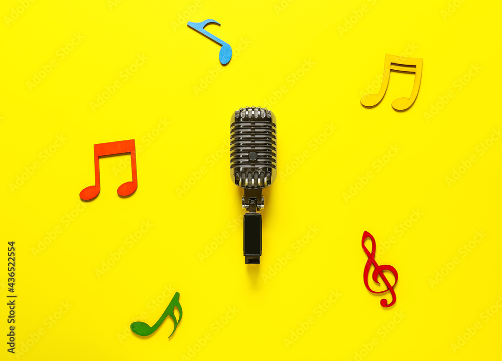 Retro microphone with music notes on color background