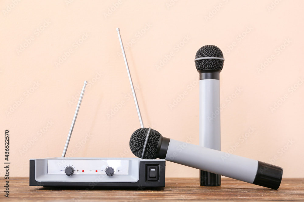 Modern microphones with audio system on color background