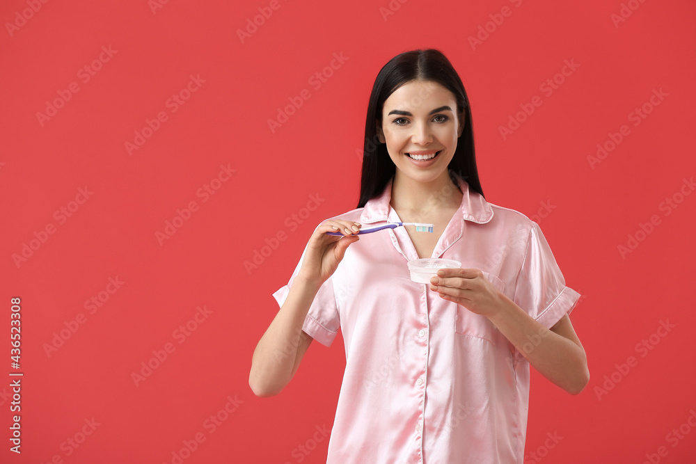 Beautiful woman brushing teeth on color background