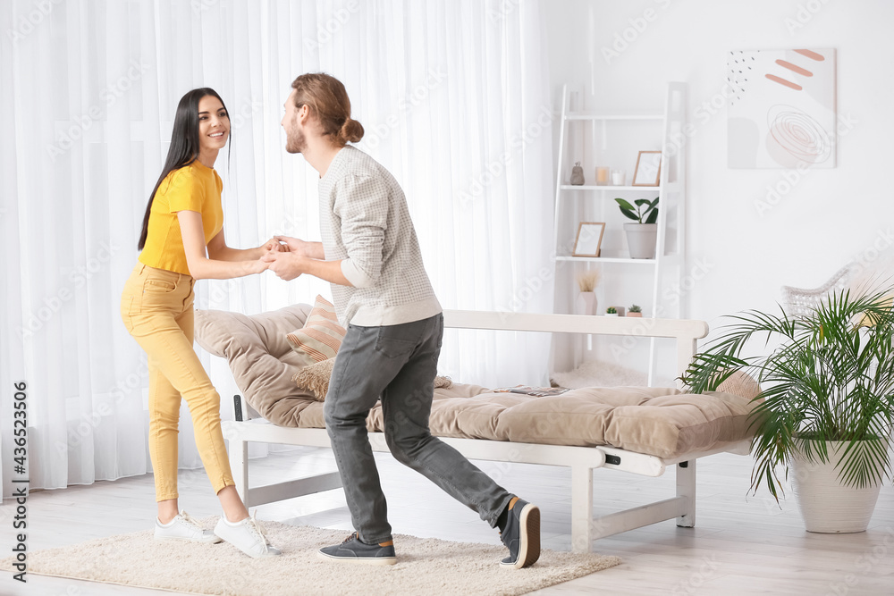 Happy young couple dancing at home