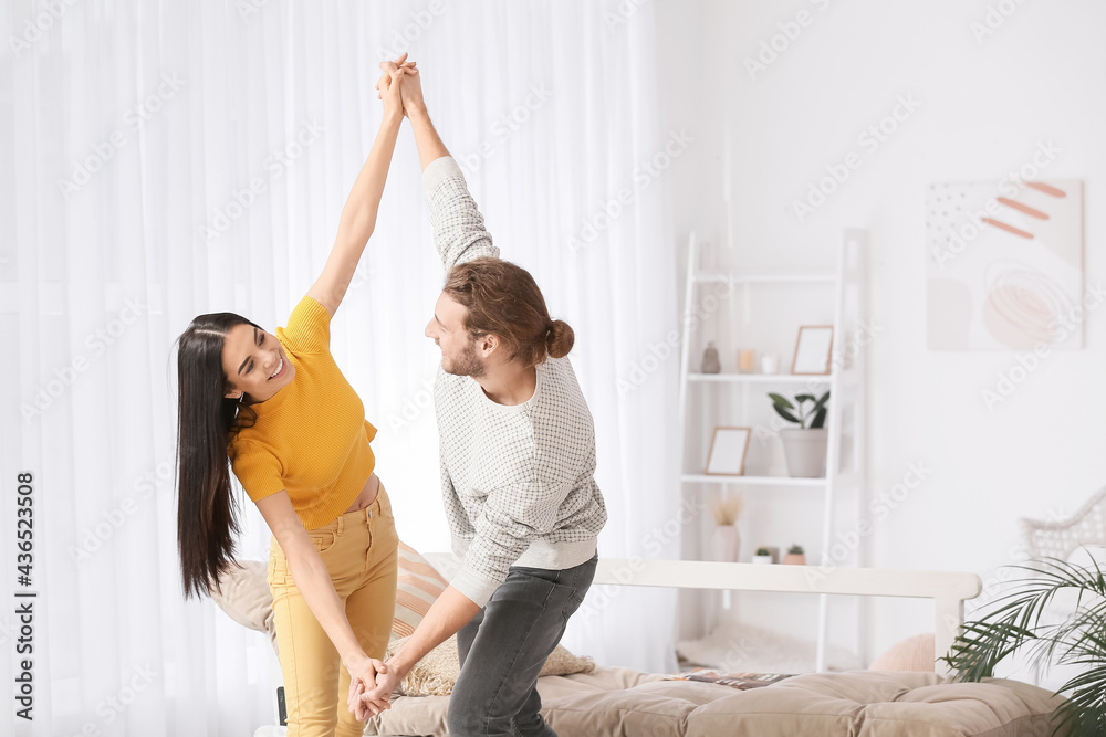 Happy young couple dancing at home