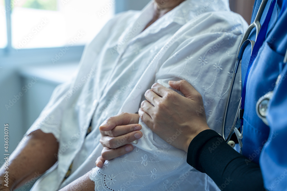 Doctor taking care of elderly woman at hospital,Composite image of nurse holding patient hand,Geriat