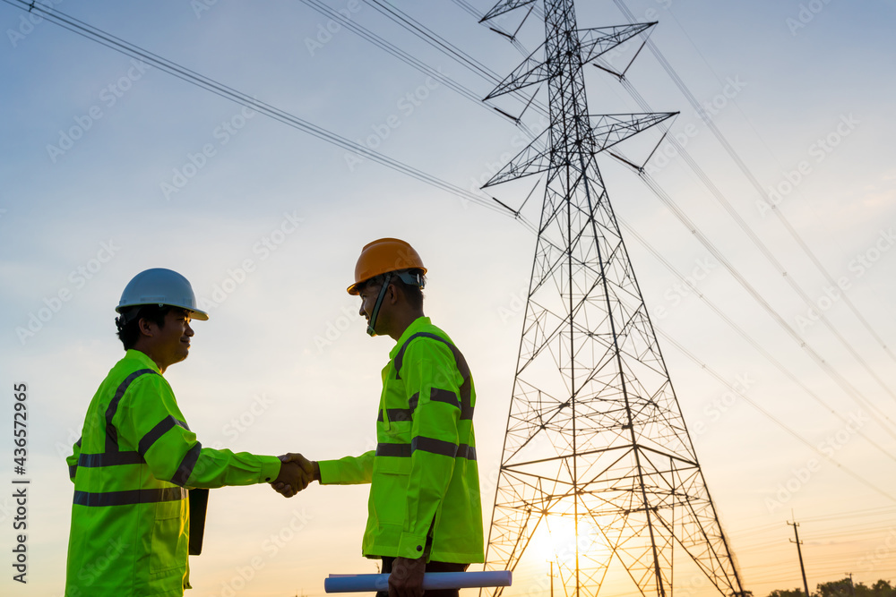 Team work of Engineers and Technician handshake after work inspections at the electric power station