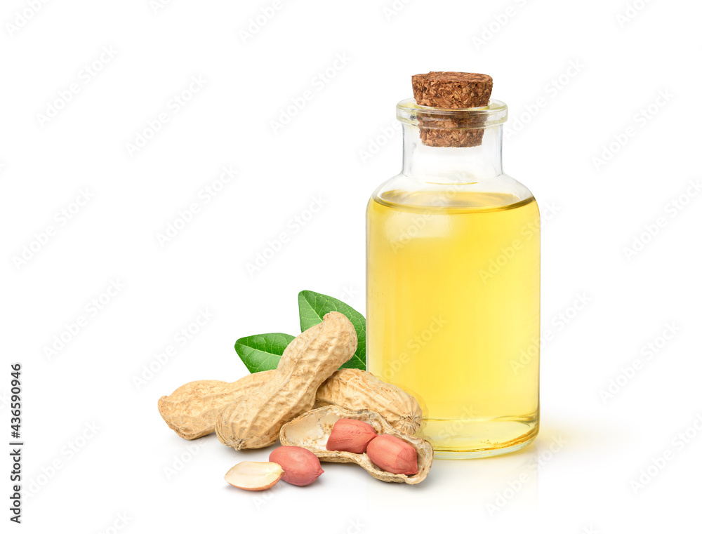 Peanut oil with peanuts and leaves isolated on white background.