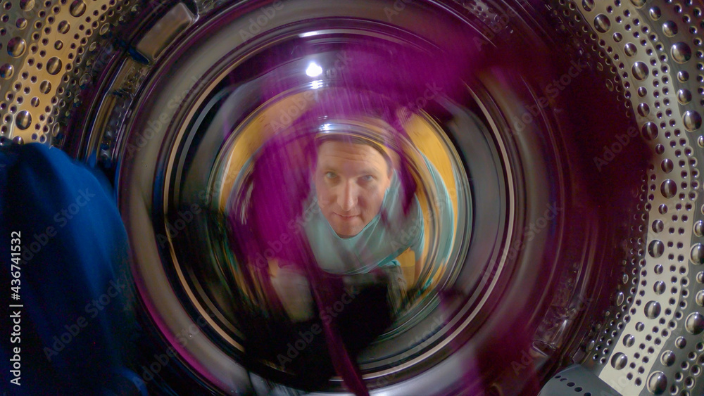 PORTRAIT: Man housekeeping over the weekend watches his clothes getting washed.