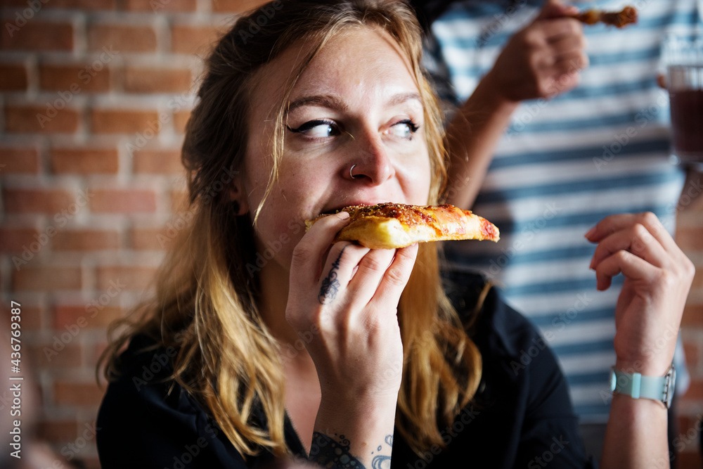 Friends eating pizza together at home