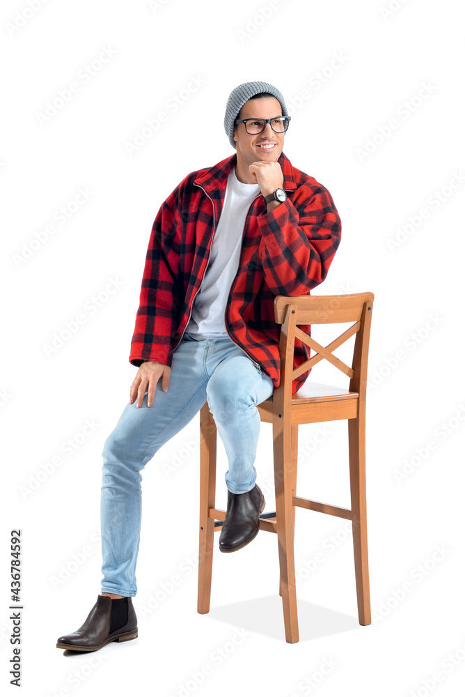 Fashionable young man sitting on chair against white background