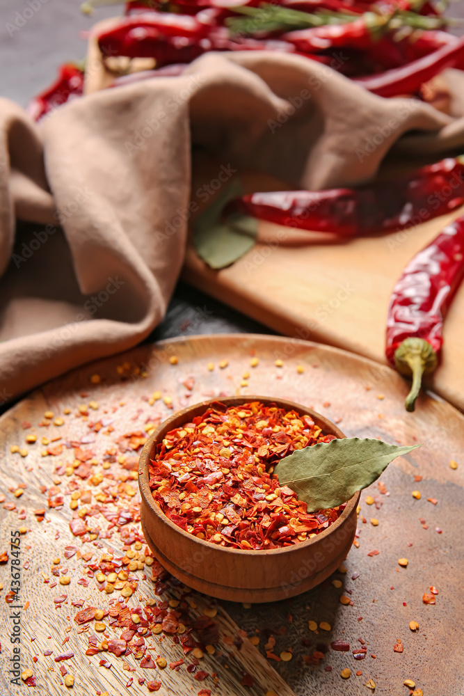 Bowl with ground chili pepper on table