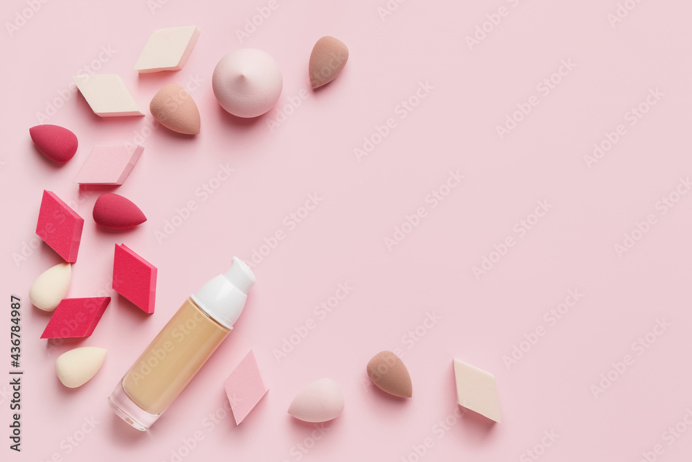 Makeup sponges with bottle of tonal foundation on color background