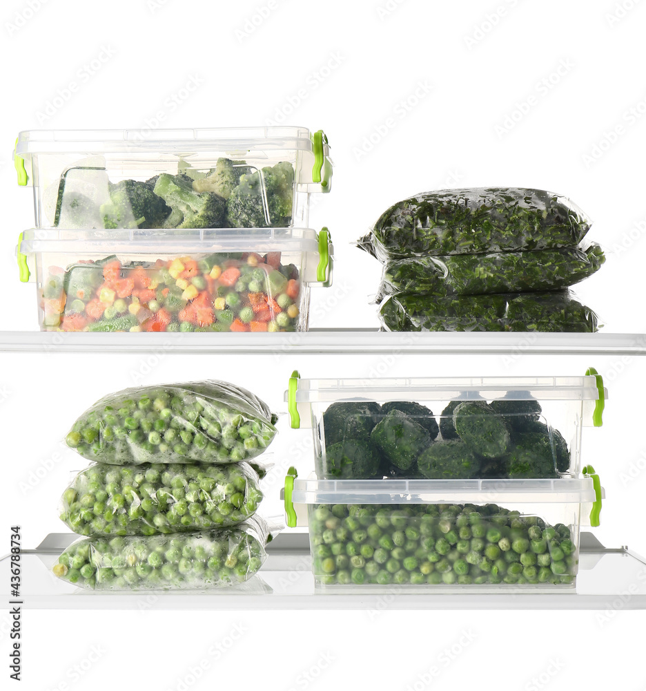 Plastic containers with frozen vegetables on white background