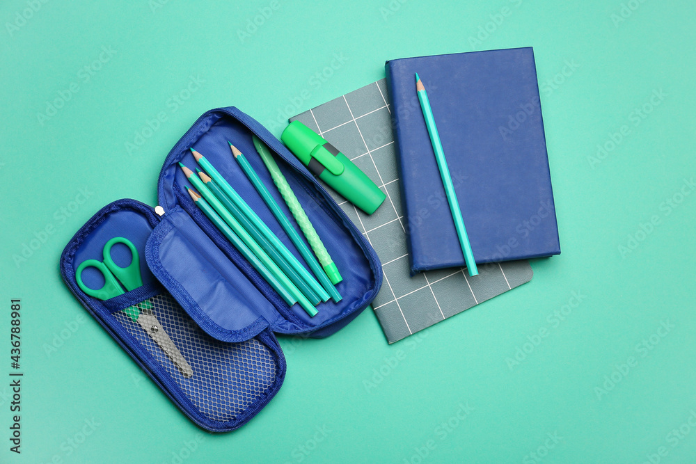 Pencil case and stationery on color background