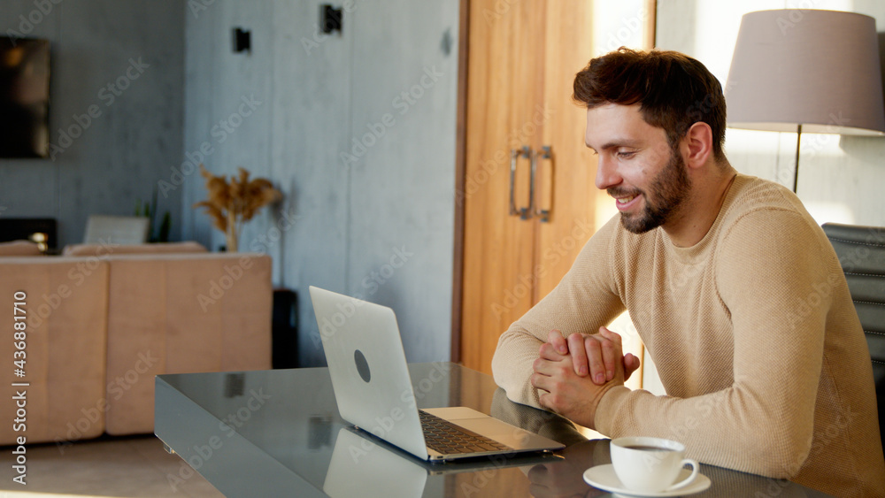 Smiling young man talking to camera making conference video call