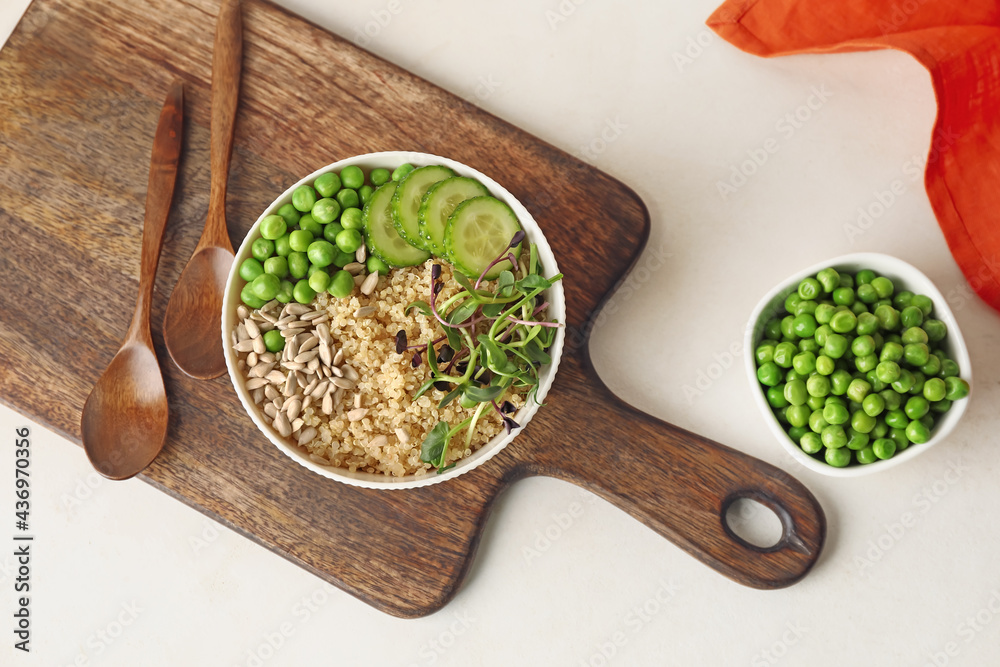 Bowl with tasty quinoa salad on light background