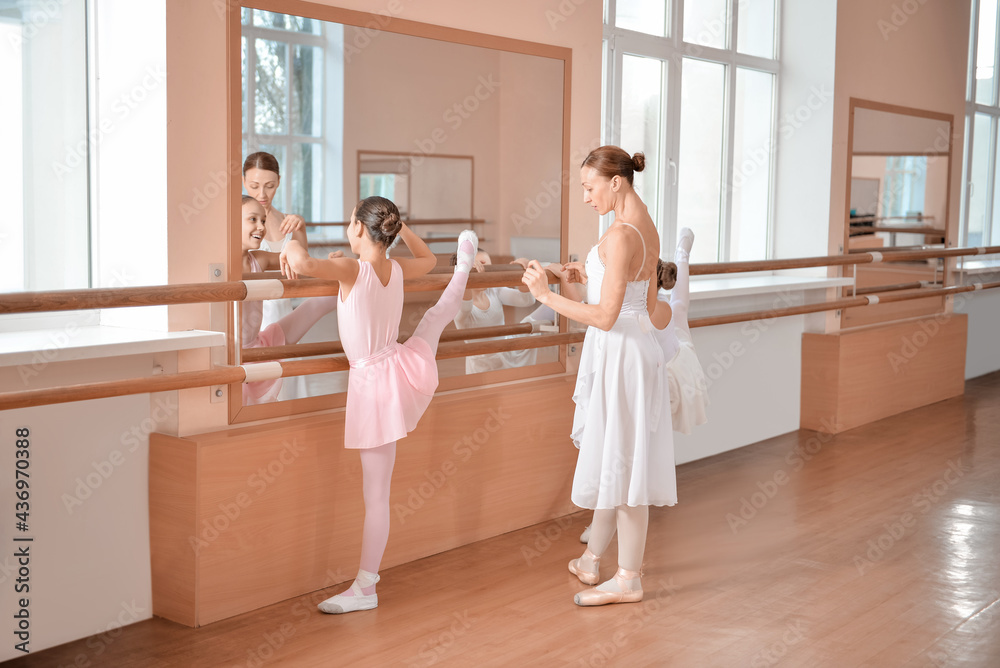 Little ballerinas training with coach in dance studio