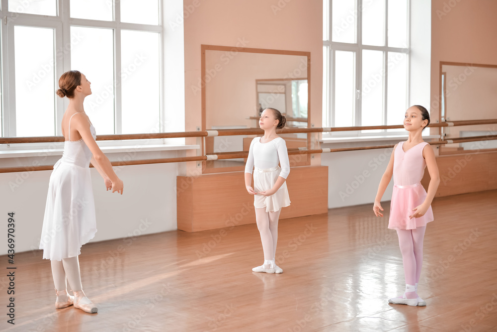 Little ballerinas training with coach in dance studio