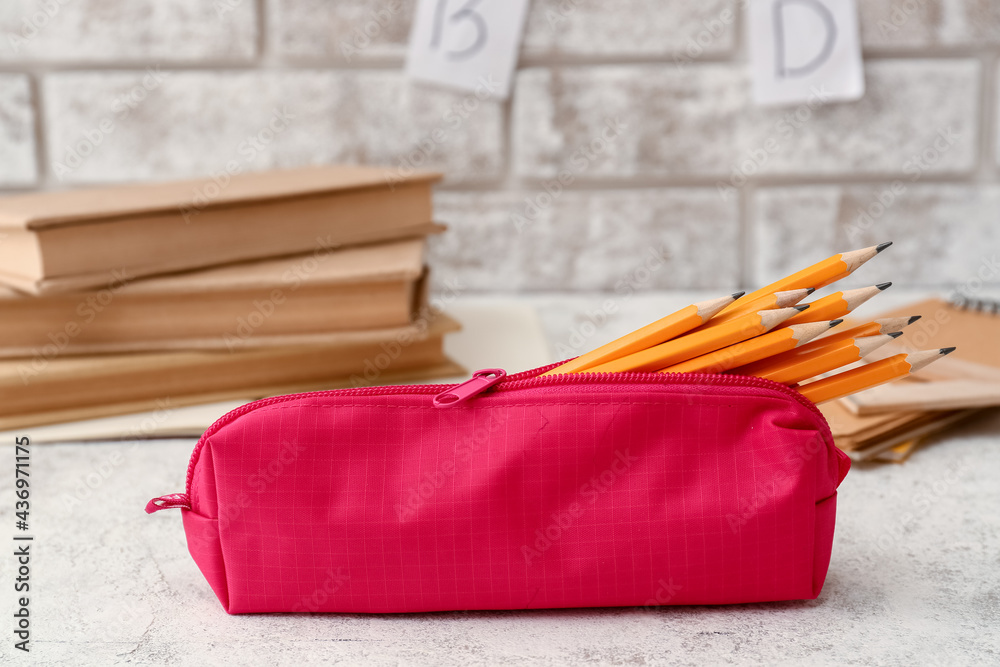 Pencil case with stationery on light table