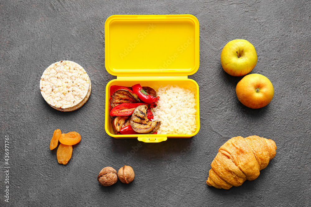 Lunch box with tasty food on dark background