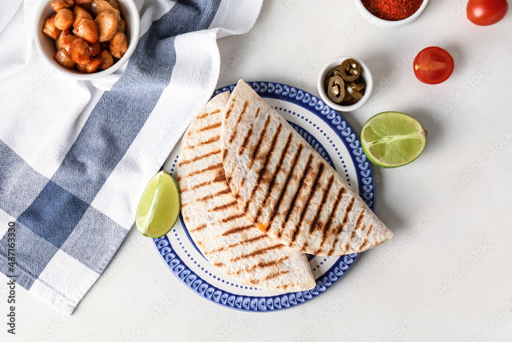 Plate with tasty quesadillas on light background