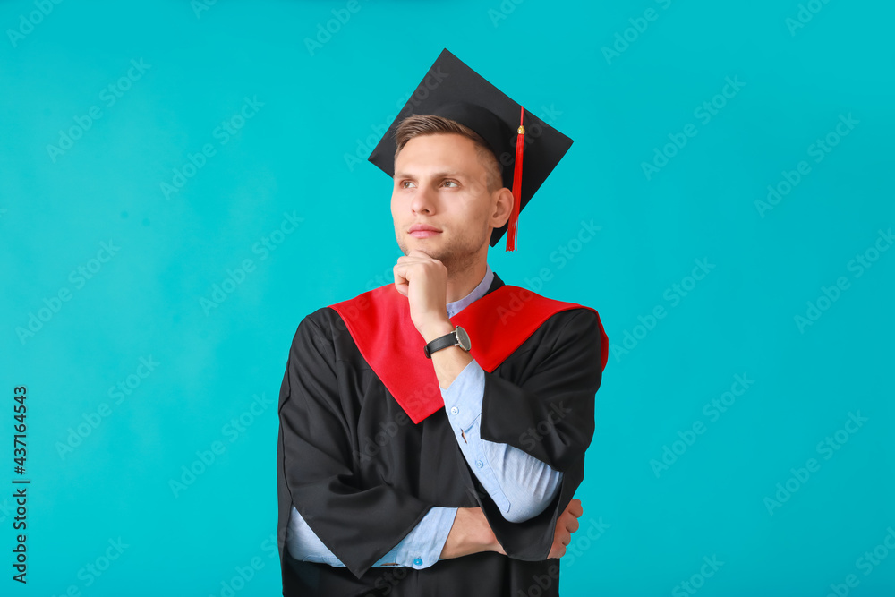 Male graduating student on color background