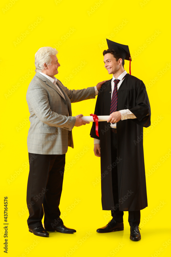 Happy male graduation student with his father on color background