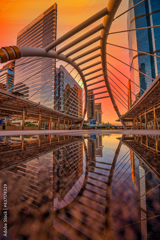 Modern structure bridge shape and building at sunset in train station, Bangkok, Thailand.