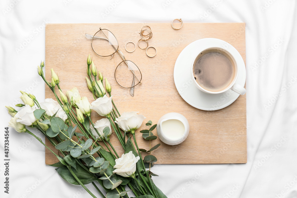 Composition with cup of coffee on bed