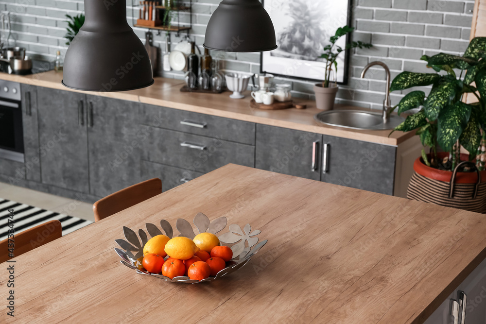 Plate with fruits on table in kitchen