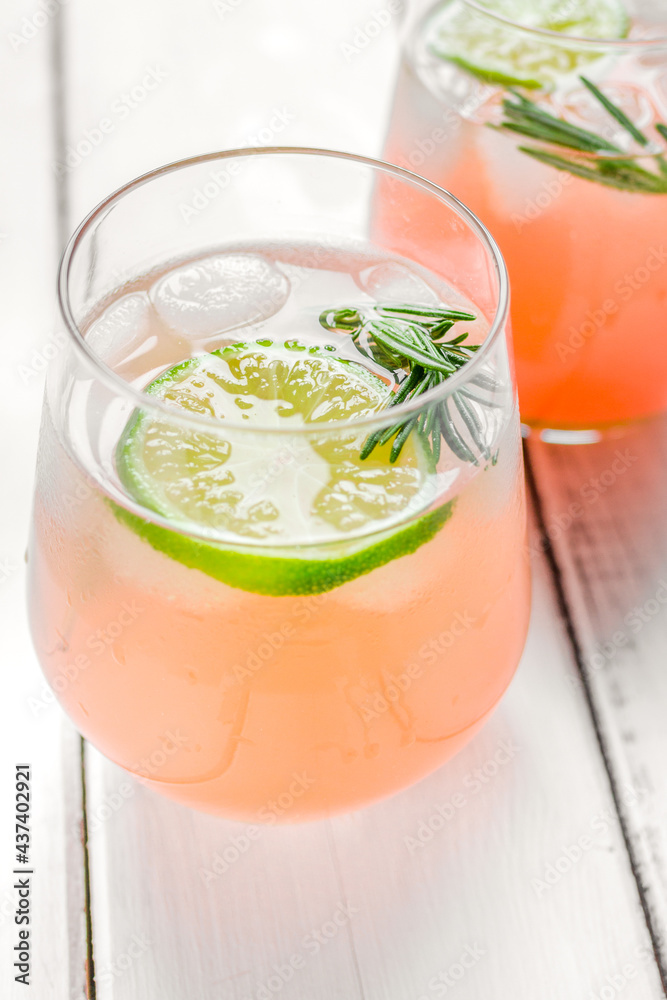 fitness cocktail in glass with lime and rosemary on white table background