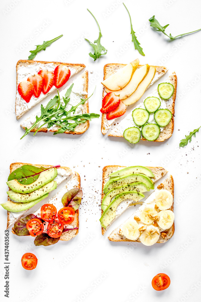 lunch with triangle sandwiches on white table background top view