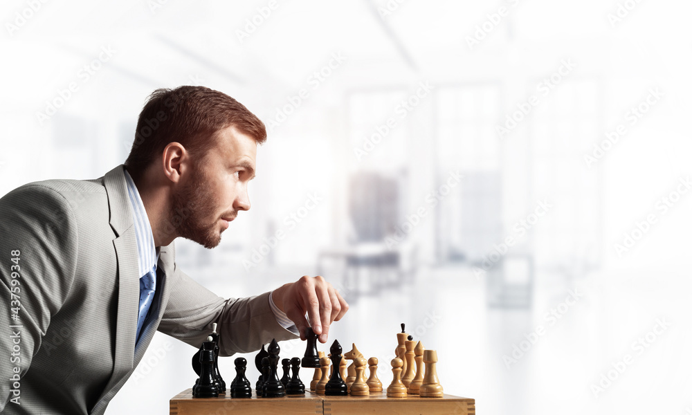 Businessman moving chess figure in chessboard