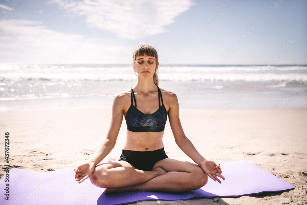 健康的女人在海滩上冥想