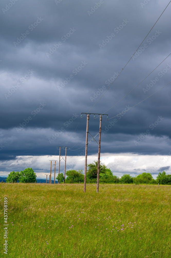 Paysage dAuvergne en Haute-Loire en France au printemps avec un ciel menaçant et des poteaux électr