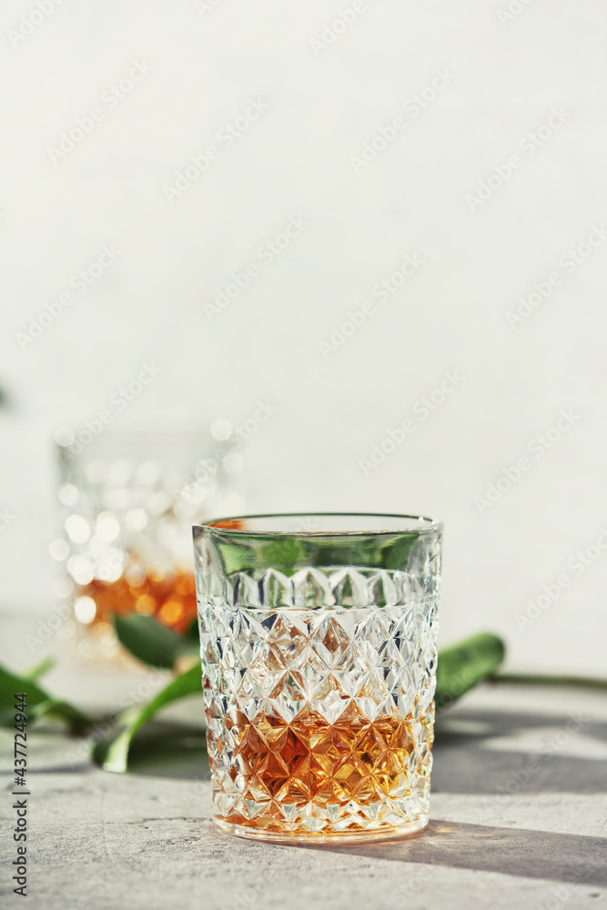 Glasses of whiskey with ice cubes close up