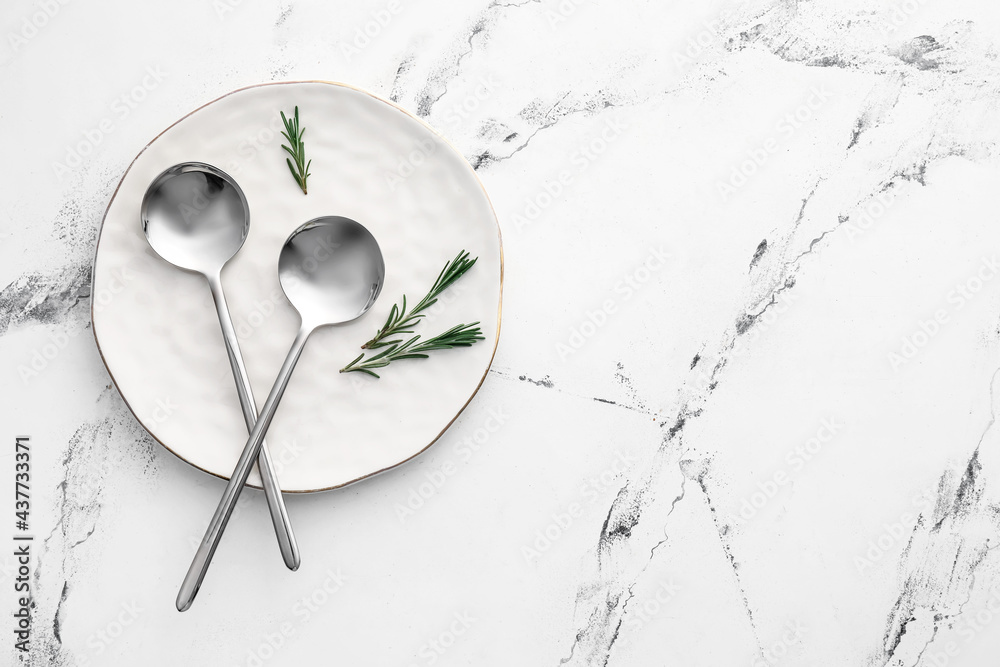 Clean spoons with plate on white background